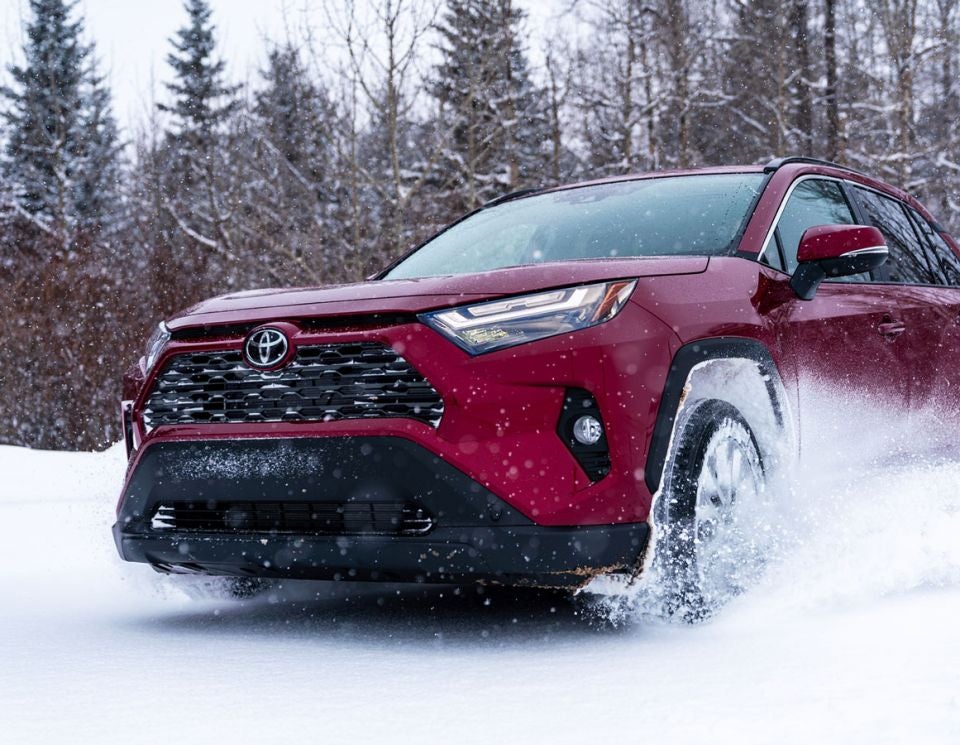a red toyota driving in snowy weather